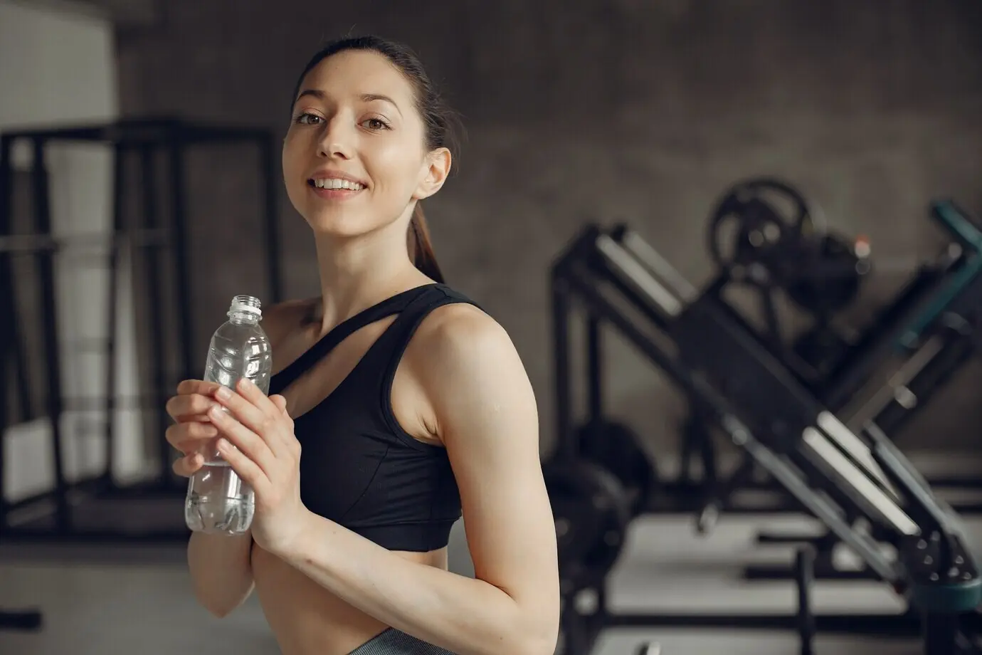 Una chica hermosa hace ejercicio en un gimnasio.